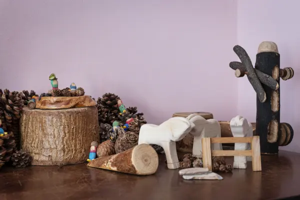 Scena naturale con tronchi, pigne e animaletti in legno